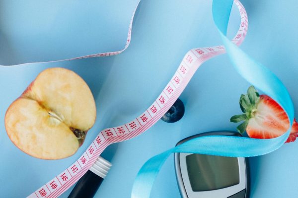 Blood glucose monitor and fresh whole fruits representing a natural approach to stopping type 2 diabetes through water fasting